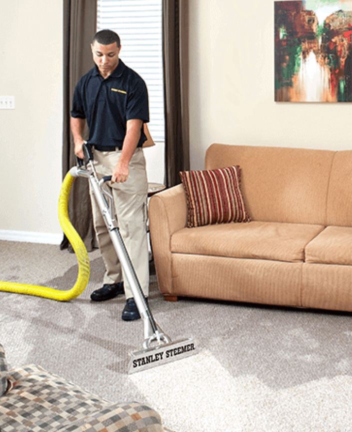 Stanley Steemer technician deep cleaning carpet