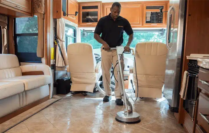 Technician cleaning a vehicle interior